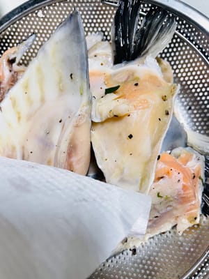 Nach dem Marinieren die Oberfläche des Fischkopfes mit Küchenpapier leicht andrücken, um überschüssige Feuchtigkeit aufzunehmen und so die Farbgebung beim Backen zu erleichtern.
