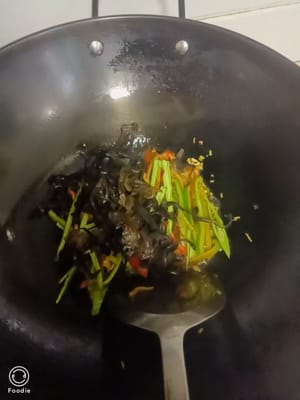锅中倒油，下蒜末姜末炒香。再下入木耳青红椒翻炒约10秒钟