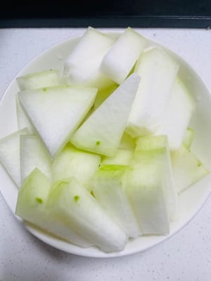 Preparación del melón de invierno
Pelar el melón de invierno y cortarlo en cubos de unos 2 cm de grosor. Enjuagar bien con agua limpia, escurrir y reservar. No cortar los cubos de melón de invierno demasiado pequeños, ya que se ablandarán después de la cocción. Este tamaño es el adecuado para conservar la forma y el sabor.