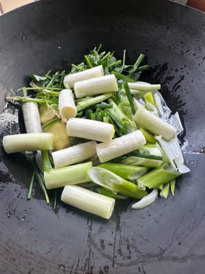 웍에 기름을 두르고 50도까지 가열한 후, 다진 파를 모두 넣고 약한 불에서 천천히 볶습니다.