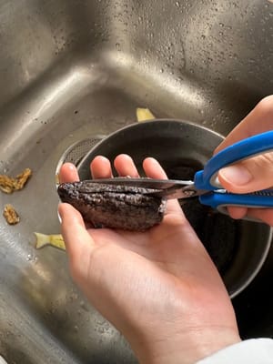 해삼이 부드러워질 때까지 물에 불린 후, 배를 가르는 부분을 따라 반으로 갈라줍니다. 앞쪽의 모래주머니, 내장(하얀 단단한 심), 그리고 안쪽 벽의 하얀 힘줄 주변의 모래를 제거합니다. 깨끗한 물로 충분히 헹궈줍니다.

모래주머니는 반드시 완전히 제거해야 합니다. 그렇지 않으면 먹을 때 거친 식감이 느껴질 수 있습니다. 안쪽 벽의 힘줄은 영양이 풍부한 부분이므로 제거할 필요가 없습니다.