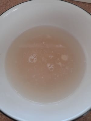 まずスターターを準備し、作ります。材料（インスタントイースト（フェルミパン）小さじ1、グラニュー糖小さじ1、ぬるま湯75ml）をボウルに入れます。約10分間、または表面に泡が出るまで放置します。