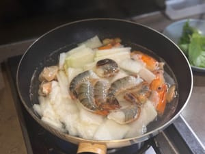 Aggiungere il melone invernale, l'acqua e i gamberetti e cuocere insieme.