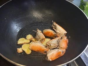 Aggiungere lo zenzero e friggere le teste dei gamberi (estrarre la freschezza).