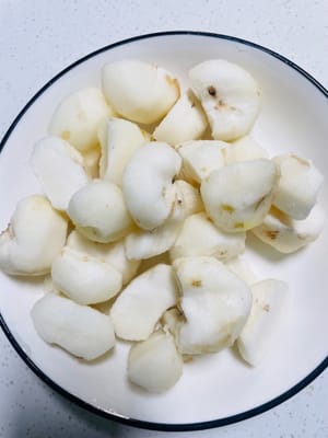 Frote la caña de azúcar con una lana de acero y córtela en trozos pequeños; pele las castañas de agua y córtelas por la mitad. Reserve todo.