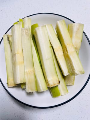 Frote la caña de azúcar con una lana de acero y córtela en trozos pequeños; pele las castañas de agua y córtelas por la mitad. Reserve todo.