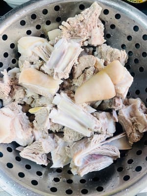 Poner las chuletas de cordero limpias en una olla con agua fría, añadir vino blanco, pimienta en grano, gajos de cebolleta y rodajas de jengibre. Después de que hierva el agua, cocinar durante 5 minutos, sacarlas, enjuagarlas con agua tibia y escurrirlas (si no están escurridas, saltearlas primero en la olla para secarlas).