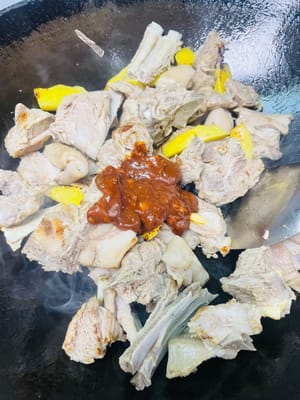 Rocíe una cucharada de vino blanco por el borde del wok para que libere el aroma, luego vierta la salsa preparada y saltee un rato para que las chuletas de cordero se impregnen de ella. A continuación, añada la raíz de angélica, la cáscara de mandarina seca, el espino blanco y la angélica sinensis, junto con las castañas de agua y la caña de azúcar. Añada una cucharada de sal como sal base y remueva todo bien.