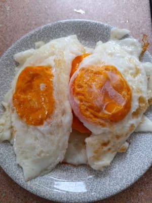 Die Eier braten, bis sie gar sind, dann herausnehmen und beiseite stellen.