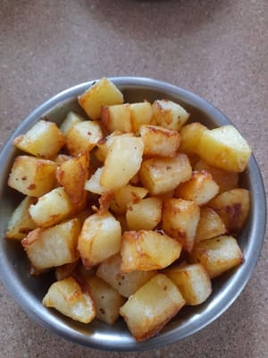 Pelar las patatas, lavarlas bien, luego cortarlas en cubos (cuadrados pequeños), escurrirlas y luego freír las patatas hasta que se pongan amarillas a fuego medio.