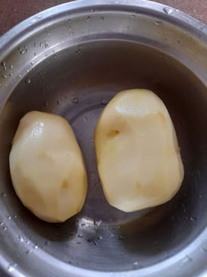 將薯仔去皮，徹底清洗，然後切成方塊（小方塊），瀝乾水分，然後用中火煎薯仔，直到變黃。