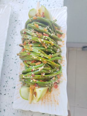 섞은 긴 콩을 하나씩 오이 랙 위에 올려놓습니다.
