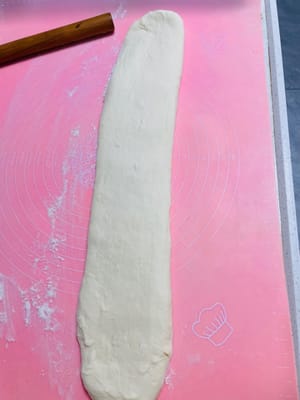Shaping the dough for the dough sticks
Take out the rested dough and roll it out on a chopping board into a 1 cm thick and 5-8 cm wide strip, similar to how you roll dumpling wrappers. Don't roll it too thin.
If the dough sticks, sprinkle it with a little flour. Do not use oil, otherwise the ends of the dough sticks will not stick together.