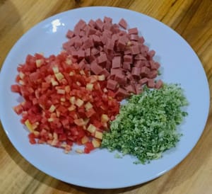 把火腿切成丁50克。西蘭花切碎50克，紅蘿蔔切丁50克。備用