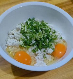 往豆腐裡打上兩顆蛋。 30克的蔥花。