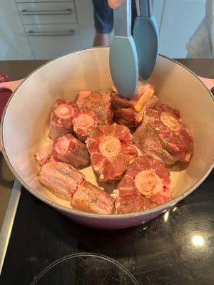 Dans une cocotte huilée, saisir les queues de bœuf assaisonnées jusqu'à ce qu'elles soient légèrement grillées. Réserver ensuite dans une assiette propre.