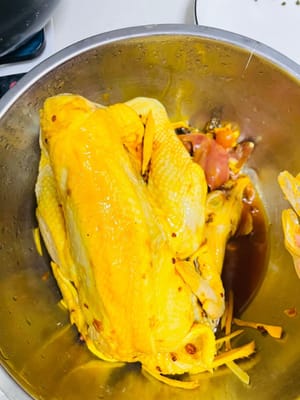Das Hähnchen abspülen und abtropfen lassen. Das Hähnchen innen und außen gleichmäßig mit Salz-Pulver bestreichen. Das Hähnchen mit geriebenem Ingwer füllen und darüber streuen. Dabei gut einmassieren, damit es den Geschmack aufnimmt. Gardenienwasser und eventuelle Reste hinzufügen, gut vermischen und über Nacht im Kühlschrank marinieren lassen (gelegentlich umrühren).