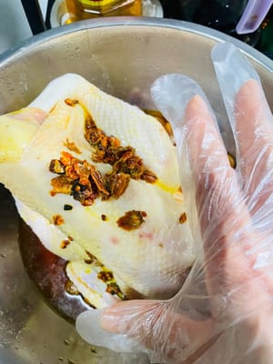 鶏肉を洗い、水を切ります。塩焼きチキンパウダーを鶏肉の内側と外側に均等に塗ります。鶏肉に千切り生姜を詰め、全体に振りかけ、味をなじませるようにマッサージします。クチナシ水と残った調味料（もしあれば）を加えてよく混ぜ、冷蔵庫で一晩マリネします（時々かき混ぜます）。