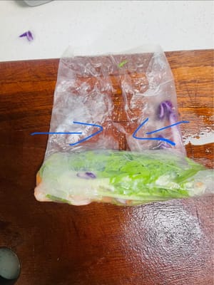 채 썬 보라색 양배추, 엔다이브, 채 썬 당근, 새우를 순서대로 준비합니다. 가장자리 쪽부터 말기 시작합니다. 약 3분의 1 정도 말았을 때, 스프링롤 wrappers의 양쪽 끝을 안쪽으로 접어 가장자리를 봉한 다음, 원하는 모양이 될 때까지 빠르게 말아줍니다. 스프링롤 wrappers가 작업대에 달라붙어 모양이 흐트러지지 않도록 모든 과정을 신속하고 효율적으로 진행해야 합니다.