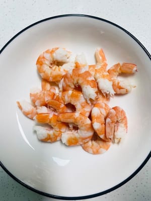 냄비에 물을 끓이고 신선한 새우를 넣어 완전히 익을 때까지 삶습니다. 새우를 건져 껍질을 벗기고 내장을 제거한 후 식힙니다.