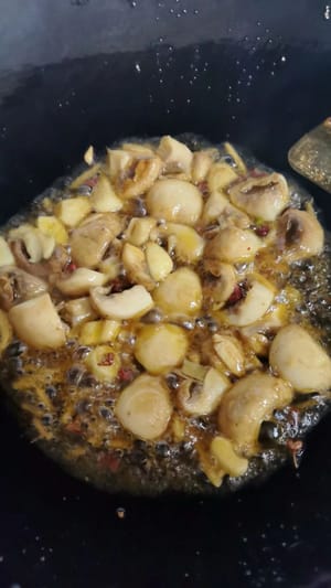 ใส่น้ำมันไว้ในกระทะเล็กน้อย ผัดขิงและกระเทียมจนหอม แล้วใส่เห็ดลงไปผัดจนเป็นสีเหลืองทอง