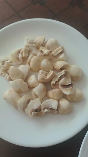 เด็ดรากเห็ดกระดุมออก แล้วหั่นเป็น 4 ชิ้น