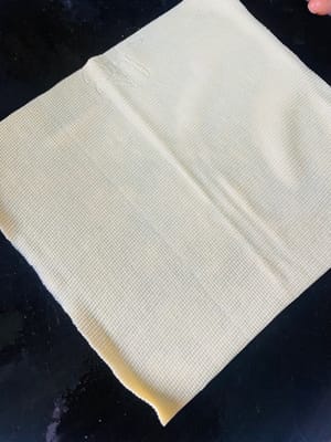 3. 由於我沒買到豆腐結，我買了千張嚟代替。每張千張長30cm，我把它分成兩半，對折後從頂角開始捲起嚟，然後打結。要是它“不聽話”，打不結實，就用牙籤紮它😀。當然，你也可以直接買現成打好結的豆腐結。