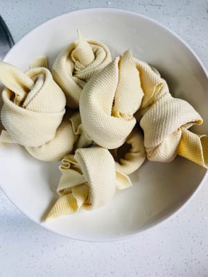 3. Da ich keine Tofuknoten kaufen konnte, habe ich stattdessen Tausendtausendblätter gekauft. Jedes Tausendtausendblatt ist 30 cm lang. Ich habe es halbiert, gefaltet, von der oberen Ecke her aufgerollt und dann einen Knoten gemacht. Wenn es „widerspenstig“ ist und sich nicht festbinden lässt, stich mit einem Zahnstocher hinein 😀. Natürlich gibt es auch fertige Tofuknoten zu kaufen.