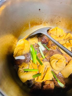 Nachdem die Luft auf natürliche Weise entwichen ist, geben Sie die vorbereiteten Tofublätter hinzu und lassen Sie alles etwa 10 Minuten lang bei mittlerer Hitze köcheln. Schalten Sie dann auf hohe Hitze und reduzieren Sie den Saft 5 Minuten lang.