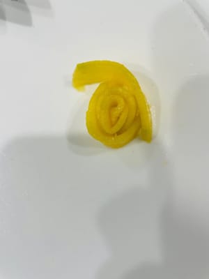 Per preparare i fiori di mango:
Mentre il riso glutinoso assorbe il latte di cocco, preparate i mango. Sbucciate il mango e tagliatelo a fettine sottili per formare i fiori. Per prima cosa, arrotolate la fetta di mango più piccola per formare il centro del fiore. Poi, avvolgete le fette di mango rimanenti attorno al centro, formando un piccolo fiore. Questo creerà un prodotto finito più bello.