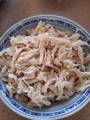닭고기를 물과 함께 끓여서 부드럽고 익힌 다음 꺼내서 물기를 빼고 찢어서 따로 보관합니다.