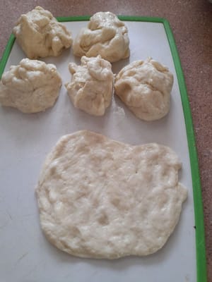 Prendere una parte dell'impasto, arrotolarla e appiattirla.