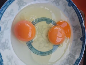 Cassez deux œufs dans un plat et ajoutez deux gouttes de vinaigre.