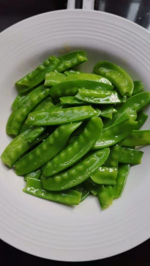 サヤエンドウの両端の筋を切り落とします。鍋に湯を沸かし、小さじ1杯の塩と数滴の油を加え、サヤエンドウを1分間茹でます。取り出して脇に置いておきます。