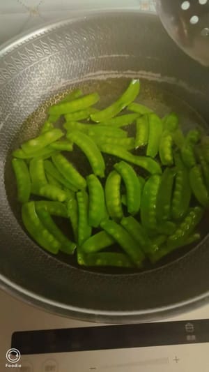 サヤエンドウの両端の筋を切り落とします。鍋に湯を沸かし、小さじ1杯の塩と数滴の油を加え、サヤエンドウを1分間茹でます。取り出して脇に置いておきます。