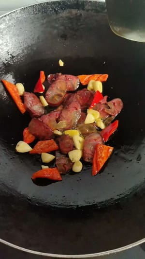 中火でソーセージが透き通るまで炒めます。湯がいたスナップエンドウを加え、火を強めて1分間さっと炒めます。少量の塩で味を調え、再び全体に火が通るまで炒め、火を止めて盛り付けます。