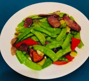 お皿に盛り付けます。ソーセージは香ばしく、とても美味しいです。スナップエンドウはシャキシャキと爽やかです。ご飯を盛り付けて、お召し上がりください！