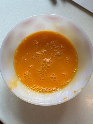 ใส่นมลงในไข่สองฟองแล้วตีให้เข้ากัน