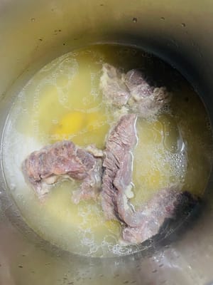 Die gewaschene Rinderbrust in einen Schnellkochtopf geben, die entsprechende Menge Wasser hinzufügen und die Angelikawurzel, die grünen Sichuan-Pfefferschalen und die Ingwerscheiben unterrühren. Sobald der Schnellkochtopf zu kochen beginnt, 15–17 Minuten kochen lassen. Den Deckel erst öffnen, wenn der Dampf verdampft ist. Bei Verwendung eines normalen Topfes etwa eine Stunde kochen lassen.