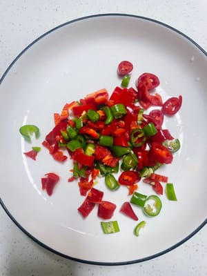 Grüne und rote Paprika klein schneiden. Wer scharfes Essen vertragen kann, sollte mehr davon verwenden, wer scharfes Essen nicht vertragen kann, sollte weniger davon verwenden.