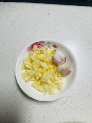 Den Knoblauch zerdrücken und hacken. Falls Schalotten vorhanden sind, ein oder zwei hacken und beiseite stellen.