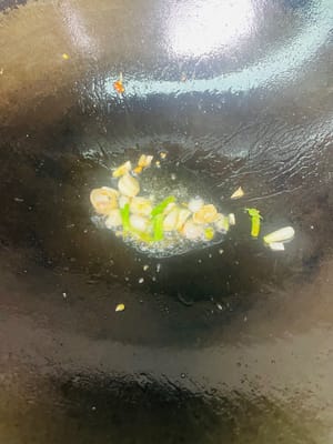 Salteado final:
Añadir un poco más de aceite al wok y sofreír las cebolletas picadas hasta que desprendan un aroma fragante. Añadir las rodajas de falda de res y sofreír durante 1 minuto. Añadir 200 ml del caldo de la falda de res y reducir a fuego medio-alto hasta que la salsa espese.
