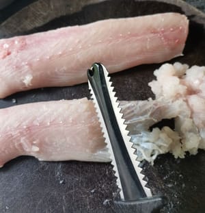 然后用锯齿刀刮鱼肉