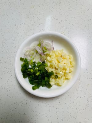薑蒜剁成蒜蓉,蔥切成粒,蔥白和蔥葉分開裝,等會兒有大用處。