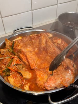 Anschließend den Schweinebauch wenden, sodass die Schwarte nach unten zeigt, und auch das Kimchi wenden, damit es nicht anklebt.