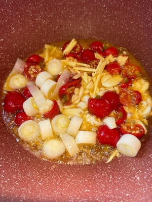 Anschließend in derselben Pfanne die eingelegten Chilischoten, den Lauch, den Knoblauch und den Ingwer hinzufügen. Unter Rühren anbraten, bis es duftet.