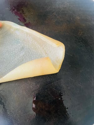 Toglietelo dal fuoco e sciacquatelo con acqua tiepida. Il segreto è raschiare via tutto il grasso all'interno della cotenna di maiale! Non potete saltare questo passaggio, altrimenti l'aspic finito sarà molto unto.