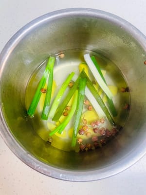 Mettete lo zenzero, i cipollotti e i grani di pepe di Sichuan in una ciotola, versate 100 g di acqua bollente per infondere l'aroma e lasciate raffreddare prima di utilizzarli. Se non avete i grani di pepe di Sichuan, potete usare l'anice stellato. Se non avete nemmeno questi, usate semplicemente acqua con cipollotti e zenzero tritati; funzionerà altrettanto bene.