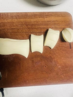 Dividere l'impasto in porzioni da circa 40 g ciascuna e stenderle in pezzi rotondi spessi circa 2 mm, leggermente più grandi e sottili delle sfoglie per ravioli.