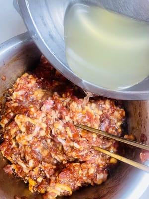 Aggiungere la salsa di soia leggera e la salsa di ostriche e continuare a mescolare nella stessa direzione fino a quando il composto non diventa appiccicoso. Quindi aggiungere un po' di fecola di patate e mescolare finché una bacchetta inserita non cade. Infine, condire con 30 g di olio di sesamo o di cipollotto. L'aroma sarà così invitante che i vostri vicini busseranno alla porta!